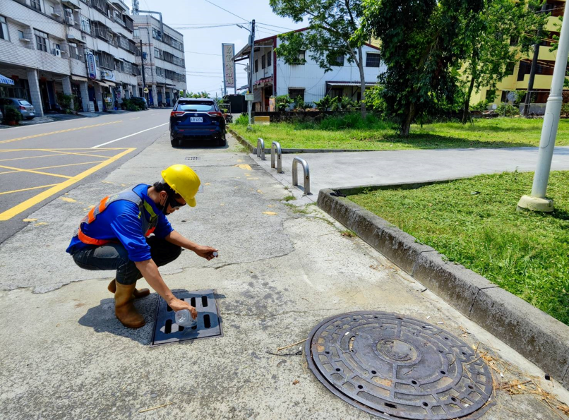 工作人員在排水口旁進行現場作業
